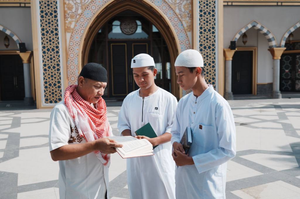 Group of men studying religious texts outside a mosque in Indonesia.