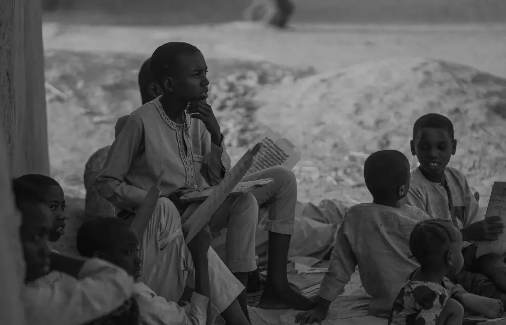 A group of children studying outdoors in Nigeria, reflecting cultural education.