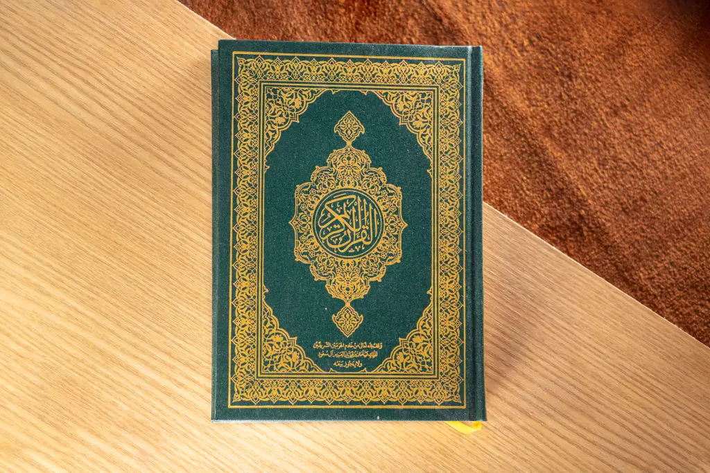 Decorative Quran resting on a wooden table, capturing a calm and serene setting.